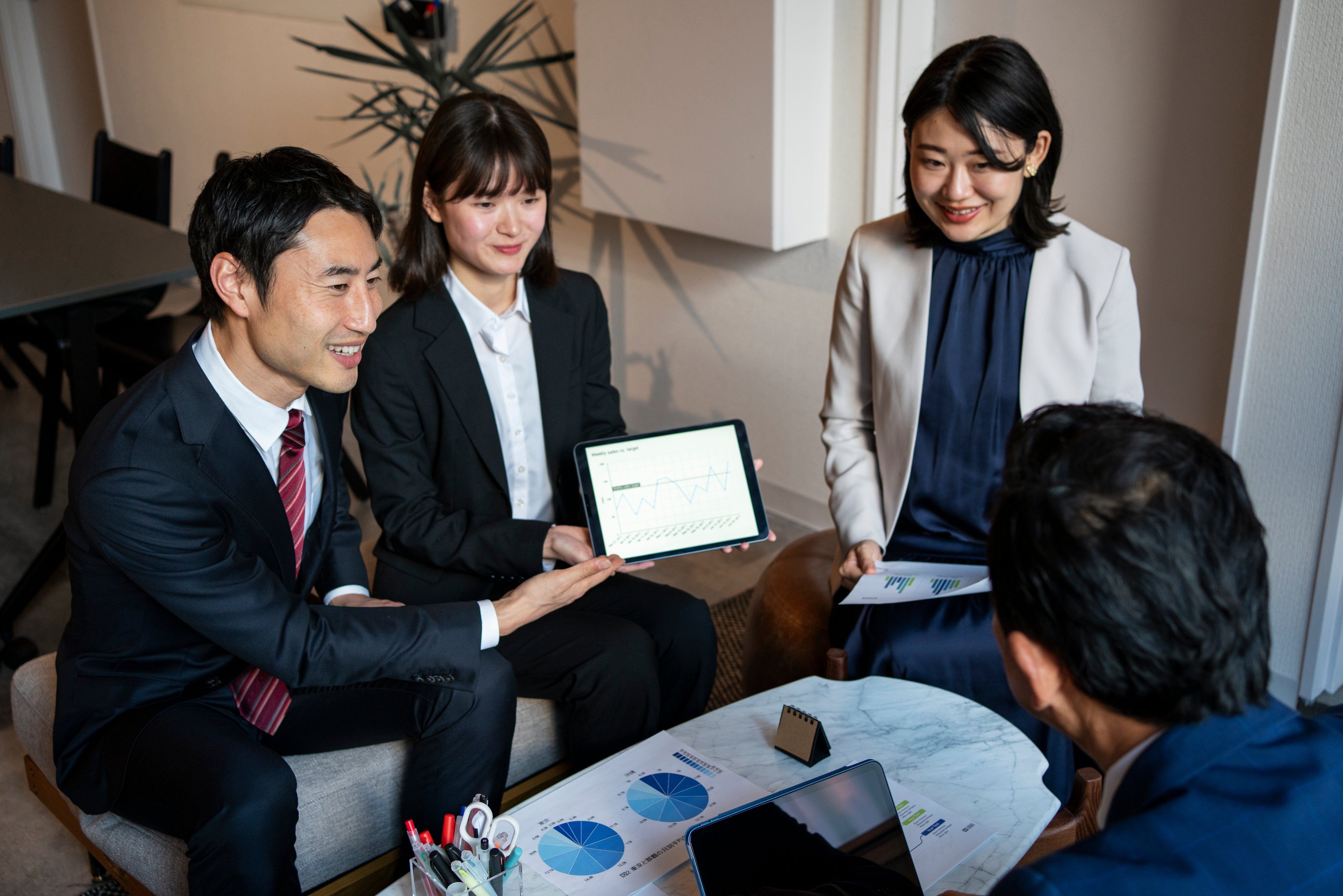 A group of professionals in a meeting, discussing work.